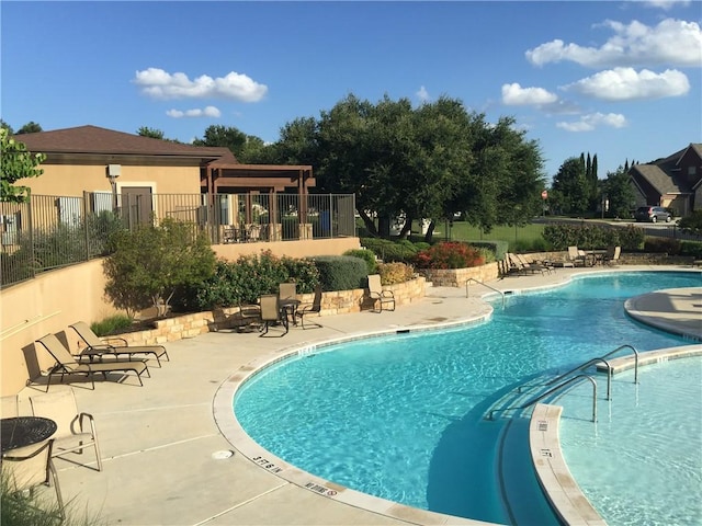 community pool featuring a patio area and fence