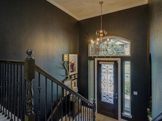 entrance foyer featuring ornamental molding and an inviting chandelier