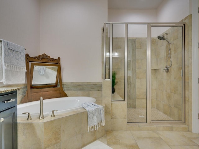 bathroom featuring a shower stall, a bath, and vanity