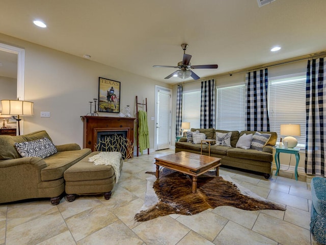 living area with baseboards, a fireplace, a ceiling fan, and recessed lighting