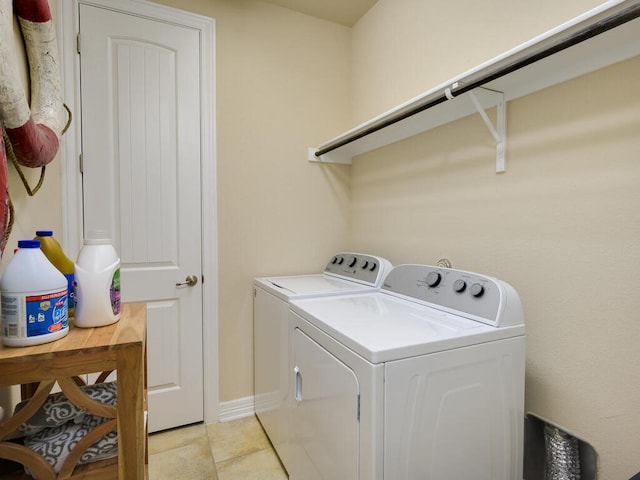 washroom with laundry area, baseboards, separate washer and dryer, and light tile patterned flooring