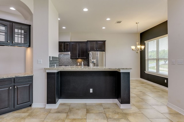 804 San Remo Blvd Unit 26B, Lakeway, TX 78734 - kitchen featuring a peninsula, visible vents, an inviting chandelier, light stone counters, and stainless steel refrigerator with ice dispenser