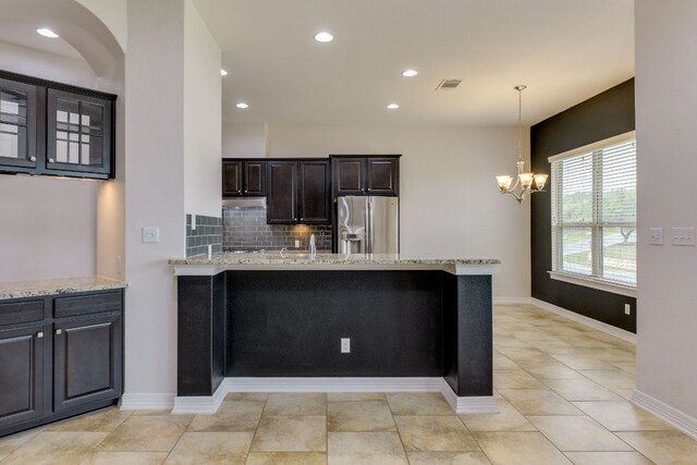 804 San Remo Blvd Unit 26B, Lakeway, TX 78734 - kitchen featuring stainless steel fridge with ice dispenser, a chandelier, light stone counters, a peninsula, and decorative backsplash