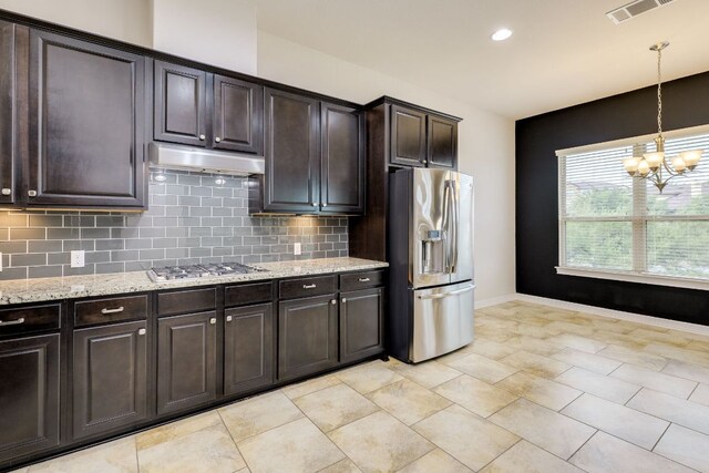 804 San Remo Blvd Unit 26B, Lakeway, TX 78734 - kitchen featuring appliances with stainless steel finishes, under cabinet range hood, a chandelier, tasteful backsplash, and light stone counters