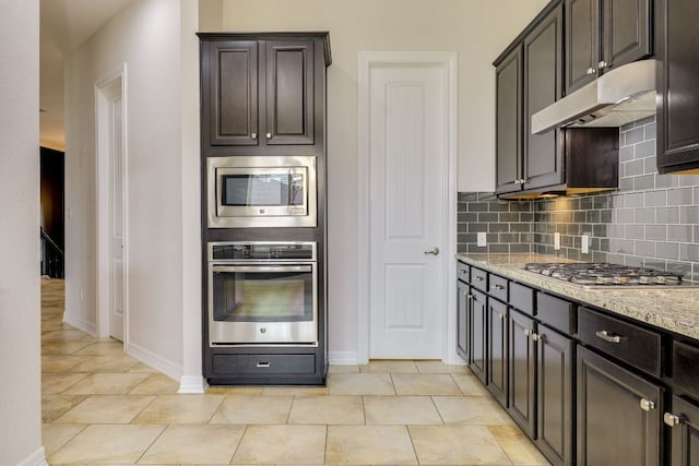 804 San Remo Blvd Unit 26B, Lakeway, TX 78734 - kitchen with decorative backsplash, stainless steel appliances, baseboards, under cabinet range hood, and light stone countertops