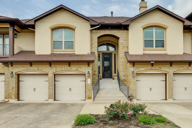 804 San Remo Blvd Unit 26B, Lakeway, TX 78734 - view of front of home featuring an attached garage, driveway, roof with shingles, and stone siding