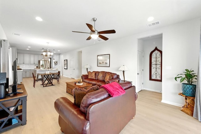 107 Trailside Ln, Bastrop, TX 78602 - living room with recessed lighting, light wood-style flooring, a ceiling fan, baseboards, and a chandelier