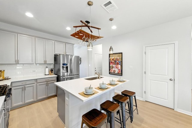 107 Trailside Ln, Bastrop, TX 78602 - kitchen with appliances with stainless steel finishes, a sink, gray cabinets, light wood finished floors, and recessed lighting
