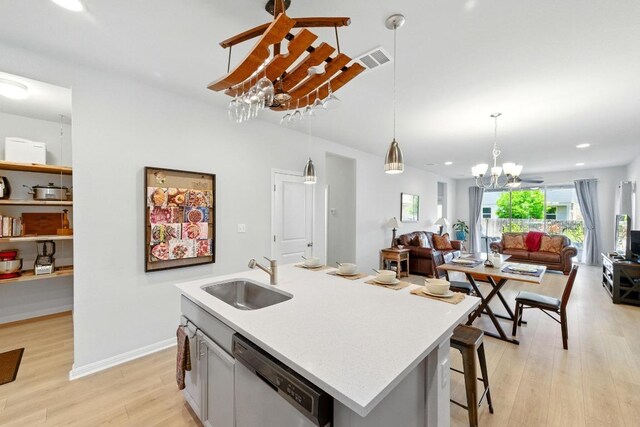 107 Trailside Ln, Bastrop, TX 78602 - kitchen with a sink, stainless steel dishwasher, a chandelier, open floor plan, and light wood-style floors
