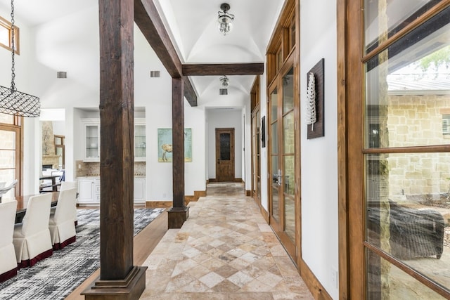 interior space with visible vents, beamed ceiling, and baseboards