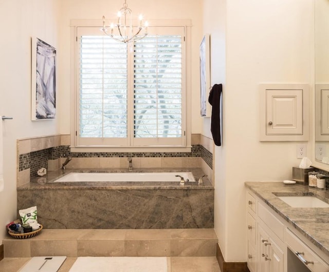 bathroom featuring a chandelier, a garden tub, and vanity