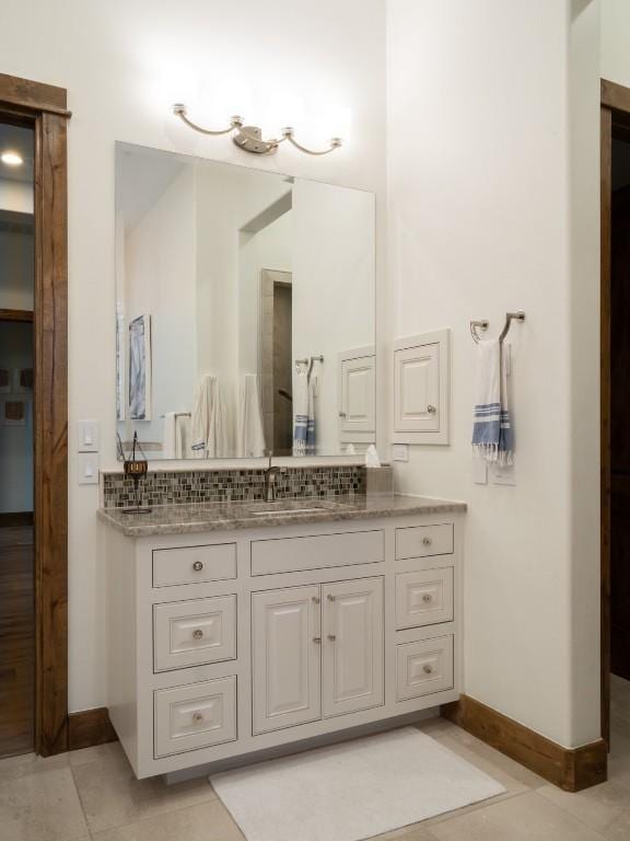 bathroom featuring tile patterned flooring, vanity, and baseboards