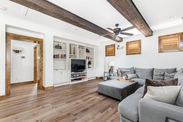 living area with beam ceiling, attic access, a ceiling fan, light wood-type flooring, and baseboards