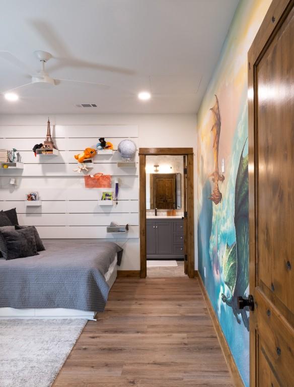 bedroom featuring light wood-type flooring, baseboards, visible vents, and a sink