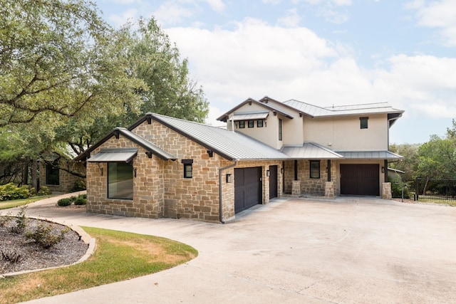 view of front of property with an attached garage, a standing seam roof, metal roof, and concrete driveway