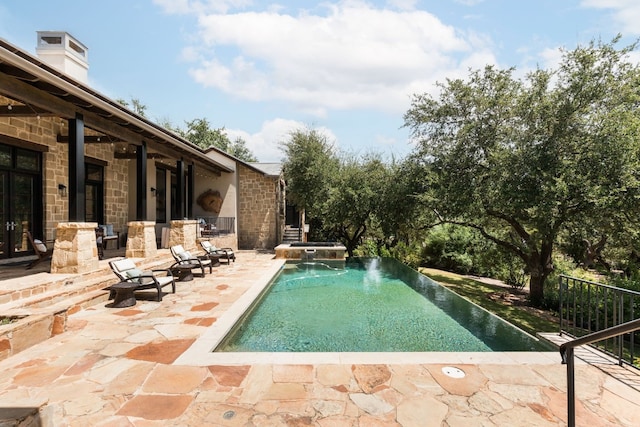 view of swimming pool with a patio area and a pool with connected hot tub