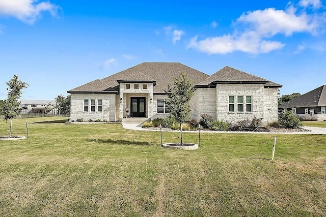 french provincial home with stone siding and a front lawn