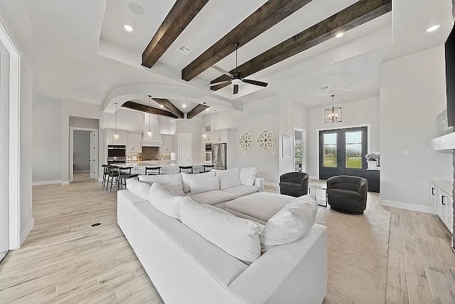 living room featuring light wood-style flooring, visible vents, baseboards, and beam ceiling