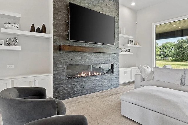 living room featuring light wood finished floors and a fireplace