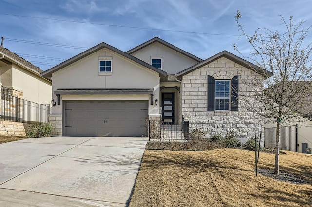 view of front of property with stone siding, fence, and concrete driveway