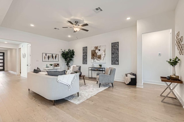 living room featuring baseboards, visible vents, a ceiling fan, light wood-style flooring, and recessed lighting