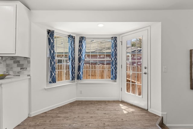 unfurnished dining area with baseboards and wood finished floors