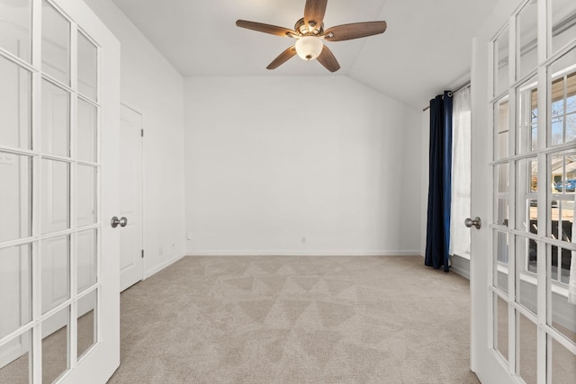 unfurnished bedroom featuring lofted ceiling, french doors, light carpet, and baseboards