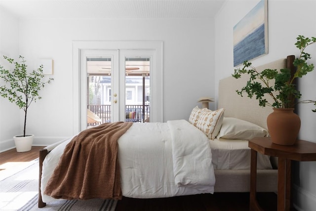 bedroom featuring access to outside, baseboards, wood finished floors, and french doors