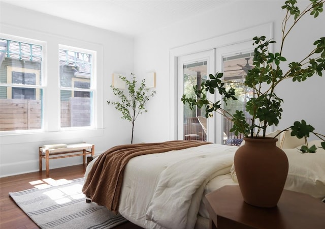 bedroom with access to outside, french doors, baseboards, and wood finished floors