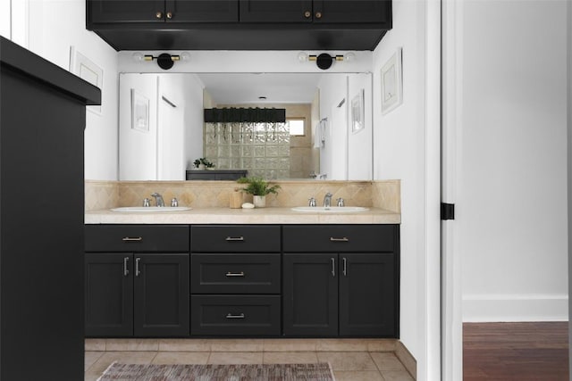 bathroom featuring double vanity, tasteful backsplash, tile patterned flooring, and a sink