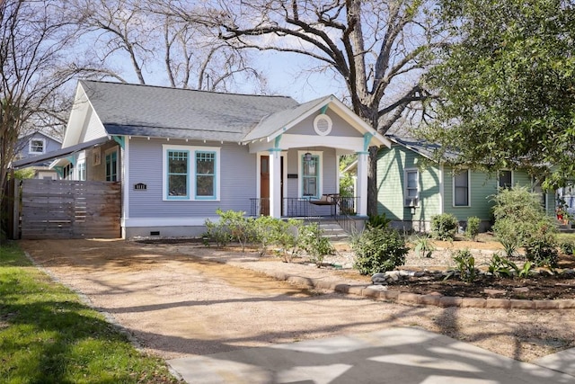 bungalow-style house with a porch, crawl space, driveway, and a shingled roof