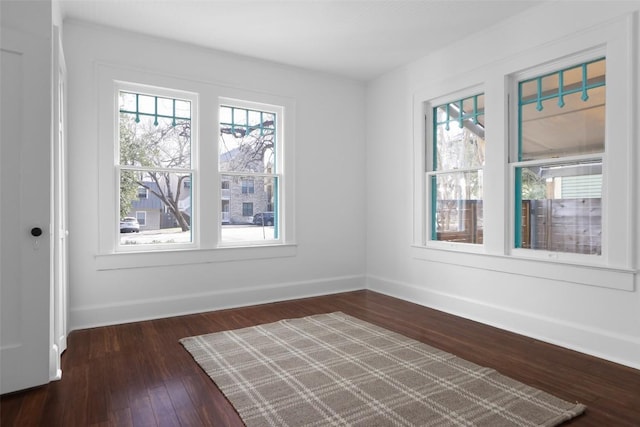 unfurnished room with dark wood-style floors and baseboards