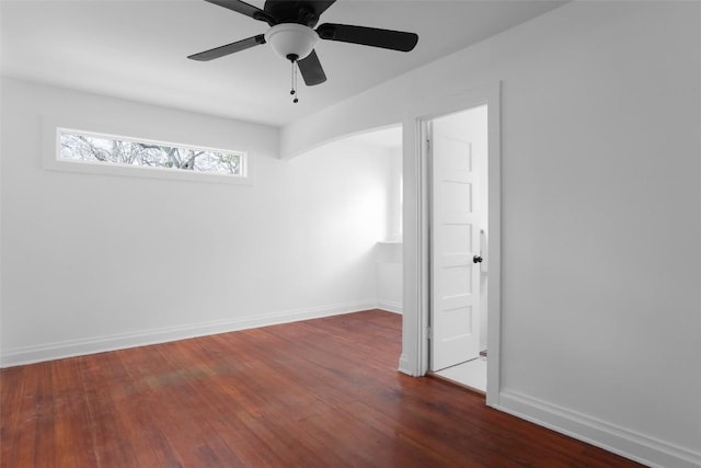 spare room featuring a ceiling fan, baseboards, and wood finished floors