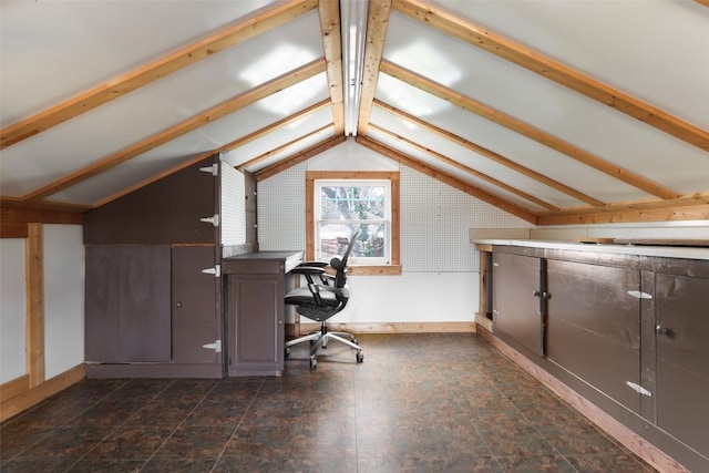 unfurnished office with lofted ceiling with beams and baseboards