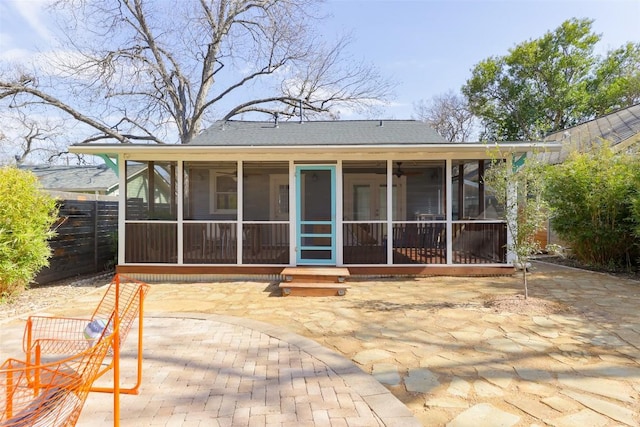 rear view of property featuring a patio, fence, and a sunroom