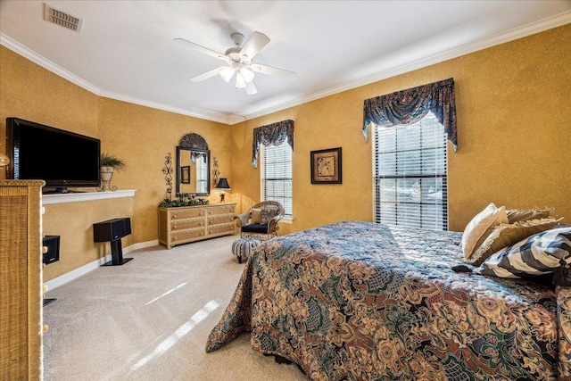 carpeted bedroom featuring baseboards, a ceiling fan, visible vents, and crown molding