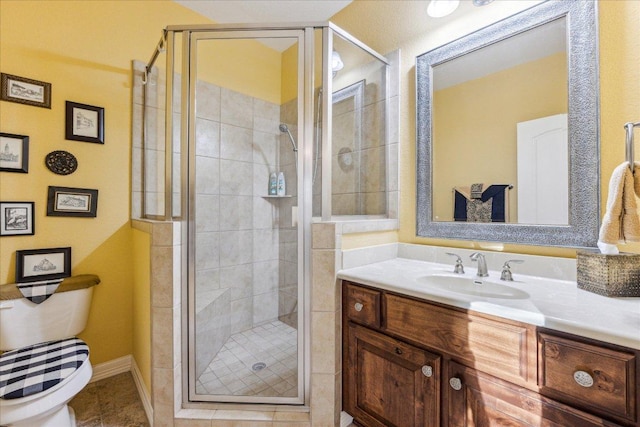 bathroom with tile patterned flooring, toilet, a shower stall, and vanity