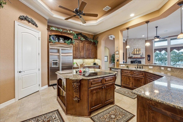 kitchen featuring visible vents, arched walkways, appliances with stainless steel finishes, a tray ceiling, and open shelves