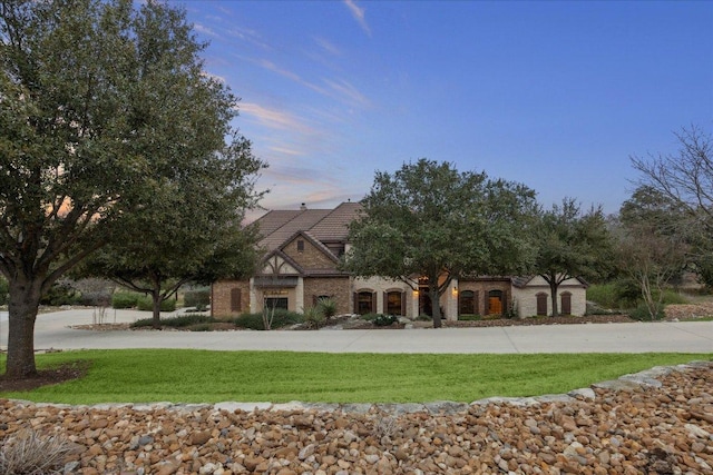 view of front of home featuring a yard and a tiled roof