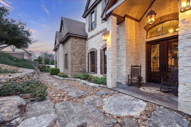 242 Saga St, Spring Branch, TX 78070 - exterior entry at dusk featuring stone siding and brick siding