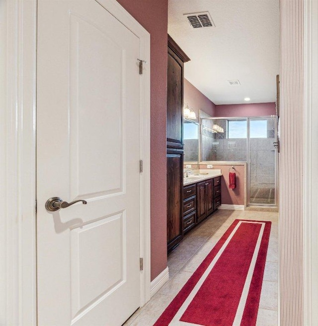 bathroom with a shower stall, visible vents, and vanity