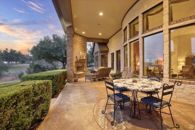 view of patio featuring an outdoor stone fireplace and outdoor dining space