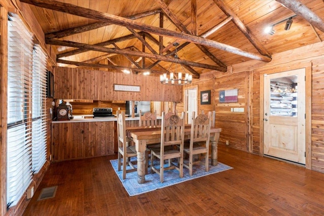 dining space with dark wood-style floors, wooden ceiling, visible vents, and wood walls