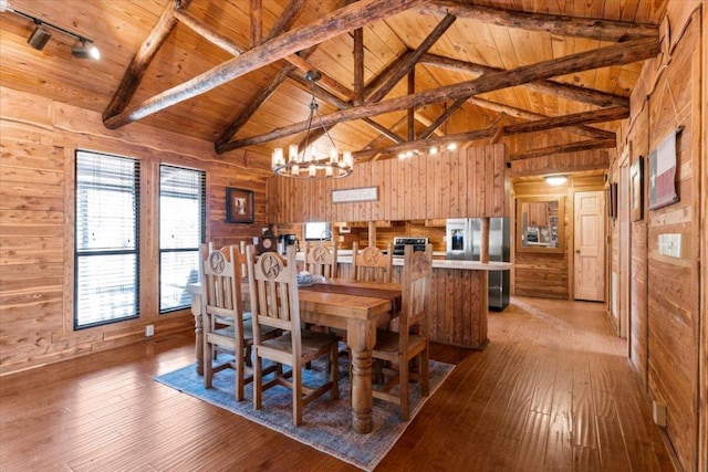 116 Yucca Ln, Bastrop, TX 78602 - dining room featuring wood walls, a wooden ceiling with exposed beams, wood-type flooring, a chandelier, and high vaulted ceiling