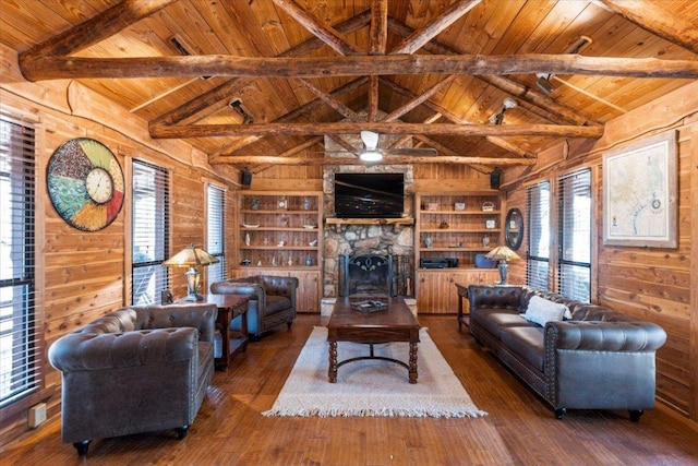 116 Yucca Ln, Bastrop, TX 78602 - living area with a wooden ceiling with exposed beams, wooden walls, healthy amount of natural light, wood-type flooring, and built in shelves