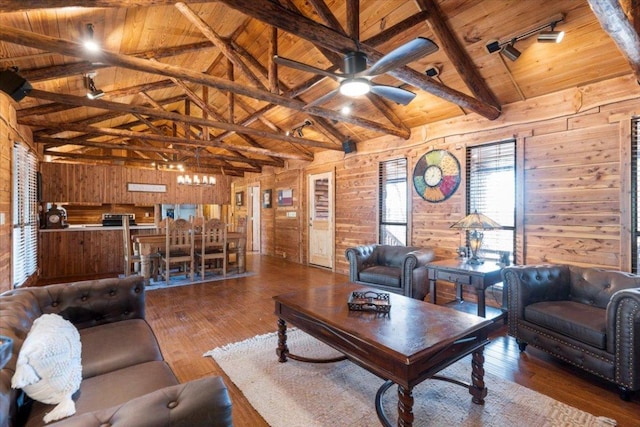 living area with wooden walls, wooden ceiling, hardwood / wood-style flooring, vaulted ceiling with beams, and track lighting