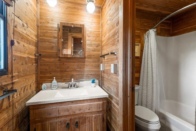 bathroom with toilet, wooden walls, and vanity