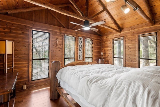 bedroom with vaulted ceiling with beams, wood ceiling, wood walls, and hardwood / wood-style floors