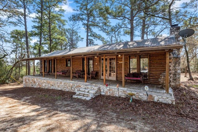 116 Yucca Ln, Bastrop, TX 78602 - rear view of property featuring a metal roof, a chimney, and log siding