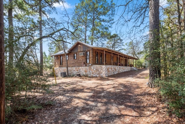 view of side of home featuring stone siding, driveway, and log siding